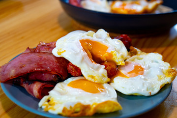 Three egg and bacon on a blue dish