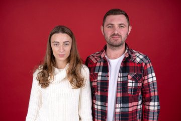 Front view of cheerful couple looking at camera isolated on red background