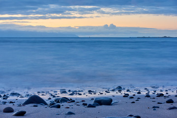 The sea after sundown and pebble beach at dawn