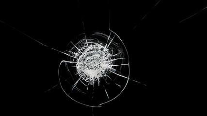 Round white cracks in glass on black background.