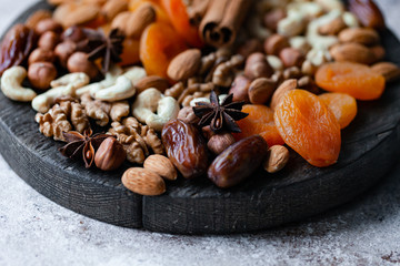 Natural healthy and delicious vegan dessert. Concept of sweet, low calories and tasty snack. Dry fruits and spices. Wooden dark rustic board, neutral background. Close up, macro 