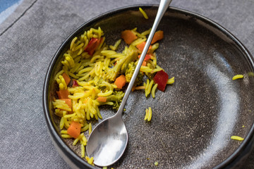Dirty unclean dishes with traces and pieces of food. Kitchenware. Finished lunch food. Indian colorful basmati rice with vegetables.