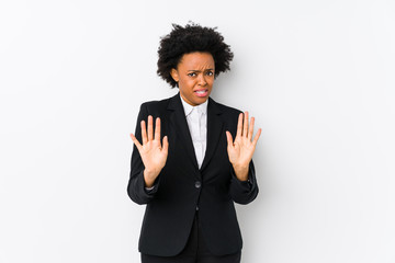 Middle aged african american business  woman against a white background isolated rejecting someone showing a gesture of disgust.