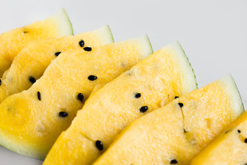 cut a slices of ripe yellow melon on a white background