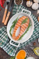 Grilled salmon filet steak with aromatic herbs, spices and vegetables. Seafood. Cooking concept. Culinary background. Table background menu. Copy space