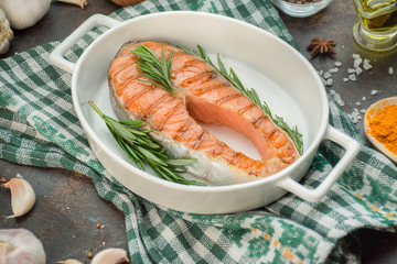 Grilled salmon filet steak with aromatic herbs, spices and vegetables. Seafood. Cooking concept. Culinary background. Table background menu. Copy space