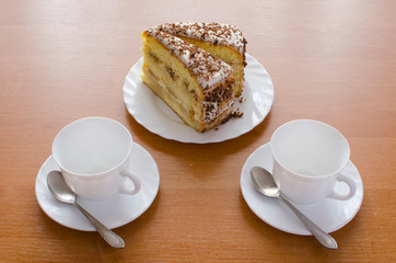Two white cups of tea and cake