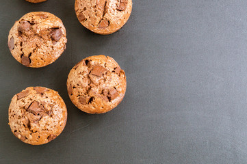 chocolate cupcakes with chocolate pieces on a black background.