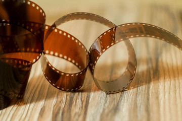 35 mm film tape blurred camera background. Wooden texture.Film photography concept. Film...