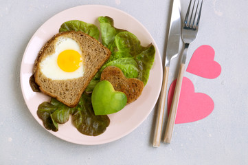Breakfast for Valentine's day. egg and toast in the shape of a heart.