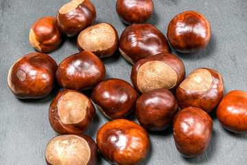 Fresh chestnut fruit scattered on grey stone background