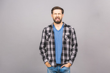 Portrait of sad upset young guy isolated over grey background.
