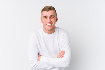 Young caucasian man on white background laughing and having fun.