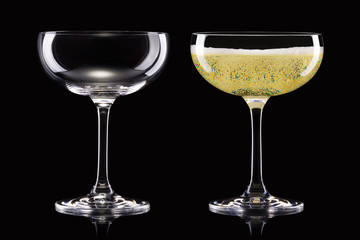 Set of empty and full champagne glasses isolated on black background.
