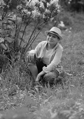 a boy in a hat walks in the spring botanical garden where flowers bloom