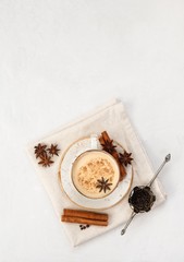 Indian Masala chai tea. Traditional Indian hot drink with milk and spices on white concrete...