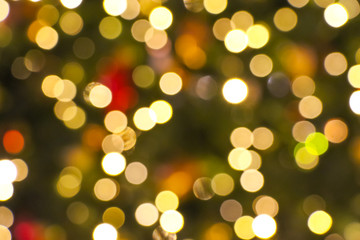 Abstract Сhristmas bokeh light background made from defocused garlands on Christmas tree. Copy space for your text and decorations. Holiday background theme.