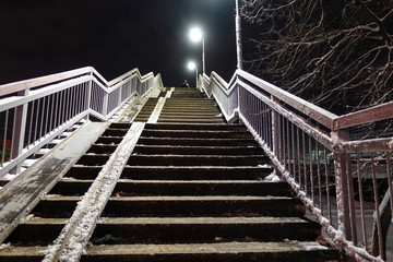 Overpass staircase at night covered in snow. Winter. Russia