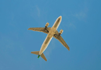 Passenger airplane on a blue sky white clouds background.Leaving flight.Selective soft focus.