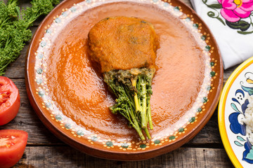 Mexican huazontles with tomato sauce on wooden background