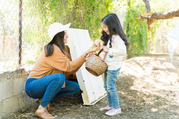 Happy Woman Giving Egg To Girl At Farm