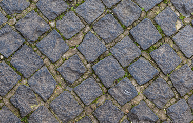 Texture of cobblestone street. Pattern of old avenue. Straight rows of stones.