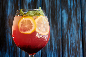 Glass of summer lemonade with blueberries, lemon and mint