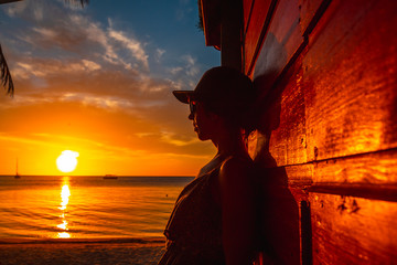 A young woman with a cap on the West End Sunset, Roatan Island. Honduras