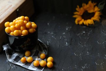 Yellow plums with lemon and lime on the black background. Ingredients for a jam. Food photography. Yellow sunflower, Autumn Concept,