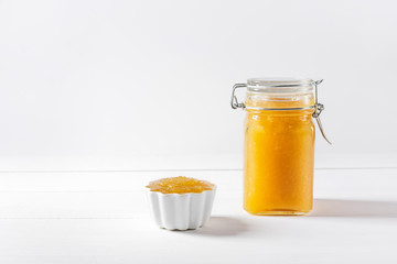 Homemade delicious fruit jam in glass jar and bowl on white background. Copy space.