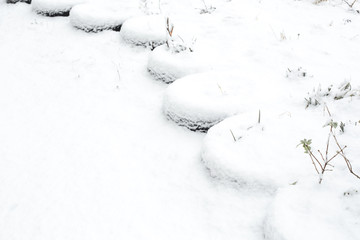 Typical winter courtyard in the CIS countries. The fence of car tires is covered with snow