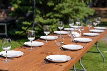Served wooden table without a tablecloth. Cafe in the open air park