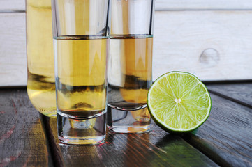 Two shots tequila with lime and salt on wooden table.Studio photography