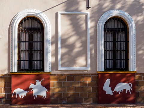 fachada con dos ventanas de madera con arcos y decoraci&oacute;n de motivos taurinos