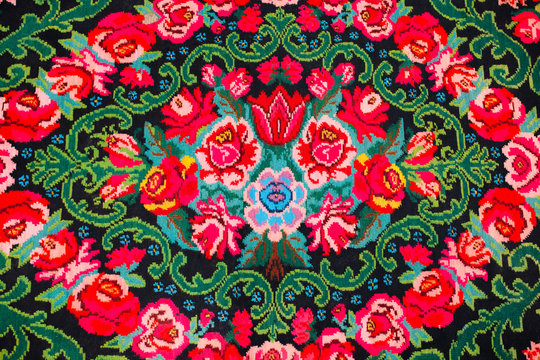 Colorful traditional vintage handmade folk carpet with floral shapes and motifs of Moldovian or Romanian traditions.