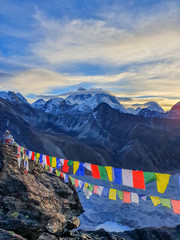Picturesque view on Everest, Nuptse, Cholatse mountains and buddhist colorful praying flags. At the top of Gokyo Ri at sunrise. Trekking in Solokhumbu, Nepal, Himalayas.
