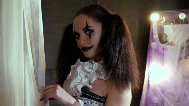 Portrait of a woman. A clown with a smile in corset with a white collar on the neck. Model with makeup for Halloween.