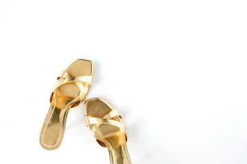 Flat lay golden women shoes on white linen. Top view minimal fashion blog background.