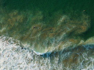 aerial view from a big wave crashing in a beach. Drone view