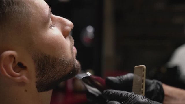 Hipster male client getting new haircut at barber shop