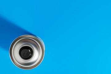 Top view of a metal paint can on a blue background