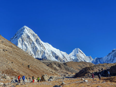Early morning view on Pumori. Trekkers heading to Gorak Shep. Everest base camp trek: from Lobuche to Gorak Shep, Nepal, Himalayas.