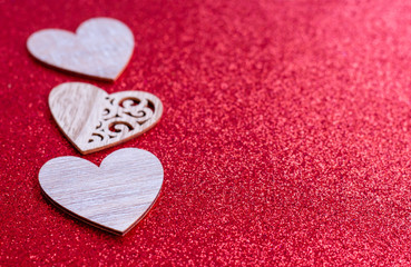 Fototapeta premium three wooden hearts on red glowing background for Valentines day, love concept, space for text