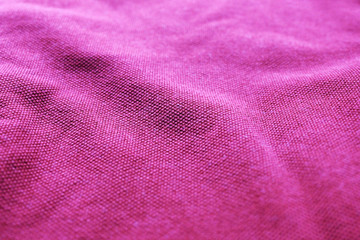 Purple rumpled fabric background, texture of wrinkled purple clothes surface. Colorful fabric of thick cotton material, fashion apparel close up low angle view 