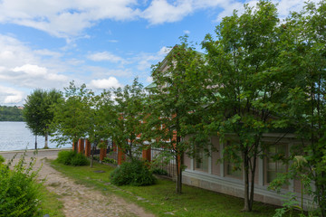 A scenic trail runs along the top of a hill above the Volga river. The path is surrounded by hedges and birches. Ples, Russia.