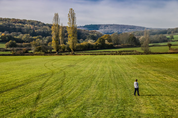 Fototapeta na wymiar enfant seul au milieu d'un champ à la campagne