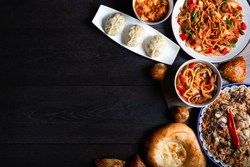 The concept of oriental cuisine. Assorted Uzbek food set, pilaf, samsa, lagman, manta, shurpa Uzbek restaurant concept, Uzbek food. Homemade Uzbek pilaf or plov from lamb served in cast iron cookware