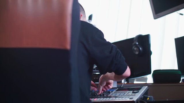 The composer makes music on a mixer in a recording studio.