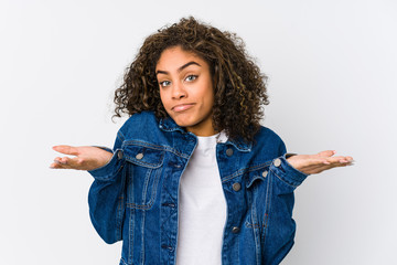 Young african american woman doubting and shrugging shoulders in questioning gesture. - Powered by Adobe