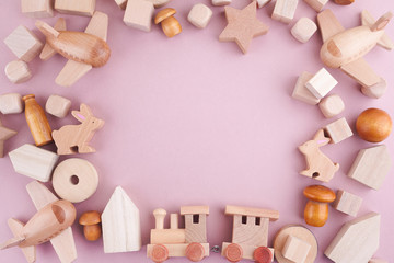 Fototapeta na wymiar Zero waste. Frame from eco wooden toys on pink background. Flat lay. Top view